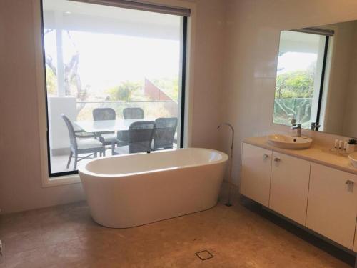 NorahSea & Sun Beach House的浴室配有白色浴缸及桌子