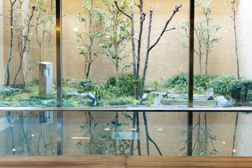 冈山冈山三井花园酒店 的大楼内带花园的玻璃台面