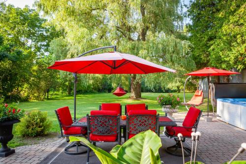 当达斯Nature Oasis Bar Room的配有红色椅子和遮阳伞的天井桌子