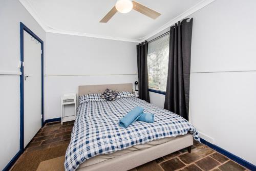 兰斯林Gone Coastal的一间卧室配有一张带蓝色枕头的床
