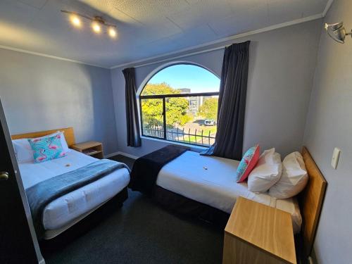 北帕默斯顿庄园汽车旅馆的酒店客房设有两张床和窗户。