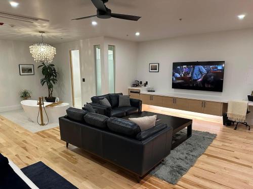 皮克顿Cribs on Main的客厅配有黑色沙发和平面电视。