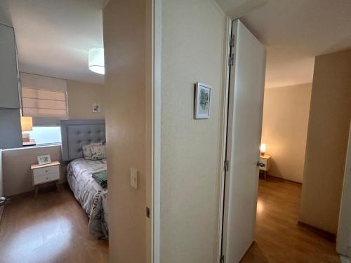 利马Acogedor apartamento centrico, tranquilo con piscina的一间卧室配有一张床,一扇门通往一个房间