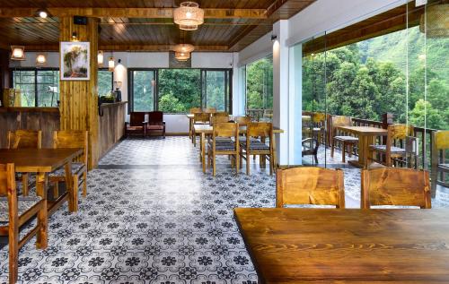 萨帕Maison de Lao Chai的餐厅设有木桌、椅子和窗户。