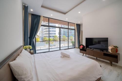 头顿Blue Sea Villa Vũng Tàu 5的卧室设有白色的床和大窗户