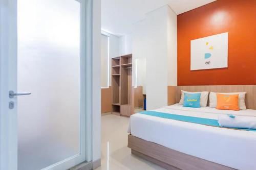 KrembanganSans Hotel Rajawali Surabaya by RedDoorz的一间卧室设有一张床和一个滑动玻璃门