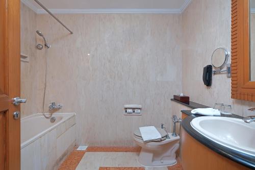 雅加达Sunlake Waterfront Resort & Convention的浴室配有盥洗盆、卫生间和浴缸。