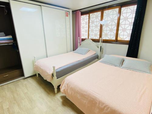 首尔Aroha house for Foreign guests only的带2扇窗户的客房内的2张床