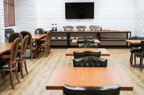 BawsharHotel Sand View的用餐室配有桌椅和平面电视。