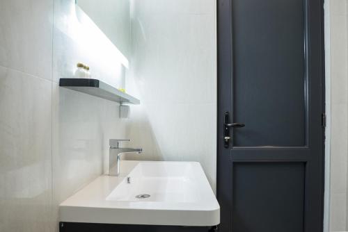 盖夫盖利亚参议员赌场汽车旅馆的浴室设有白色水槽和黑色门。