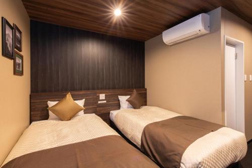 御殿场市The Celecton Gotemba Interchange的一间卧室配有两张床和空调。