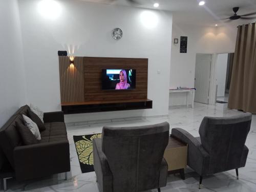 Bakar ParitHomestay Asam Pedas Parit Jawa Muar的客厅配有沙发和墙上的电视
