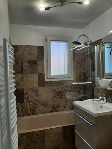 圣艾格夫Le Méditerranéo的浴室配有水槽、淋浴和浴缸。