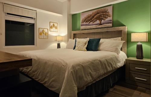 危地马拉Torre Pamplona 402 -Nuevo y Cómodo- Apartamento的一间卧室设有一张大床和绿色的墙壁