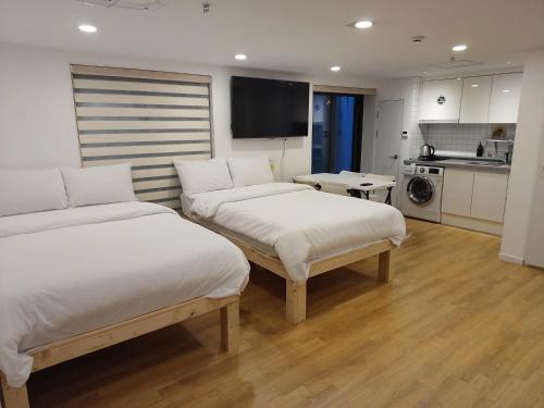 首尔318 Stay - Foreigners Only的酒店客房带两张床和厨房