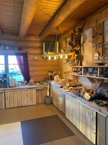 凯尔采Hotel Pod Strzechą的一间带木墙的厨房和一个带食品的柜台