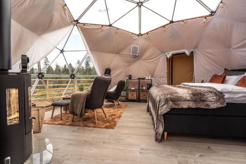 Sør-FronArctic Dome Gudbrandsdalen的帐篷内一间卧室,配有一张床和椅子