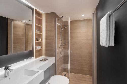 汉堡Residence Inn by Marriott Hamburg Altona的带淋浴、盥洗盆和卫生间的浴室