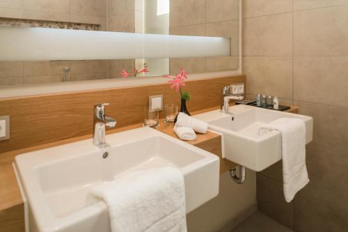 莱茵河畔路德维希港Living Apartments Ludwigshafen的白色的浴室设有两个盥洗盆和镜子