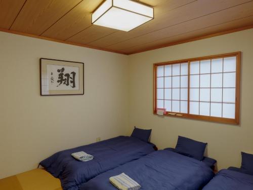 壹岐市Ikinomannaka - Vacation STAY 58080v的带窗户的客房内的两张床