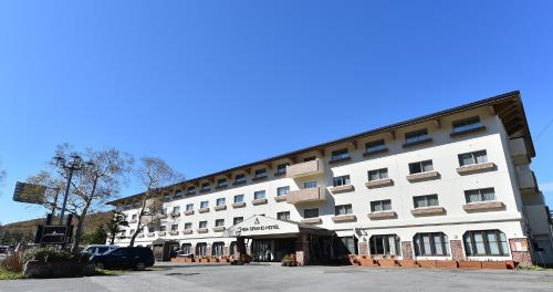 山之内町斯格大酒店的一座白色的大建筑,前面设有停车场