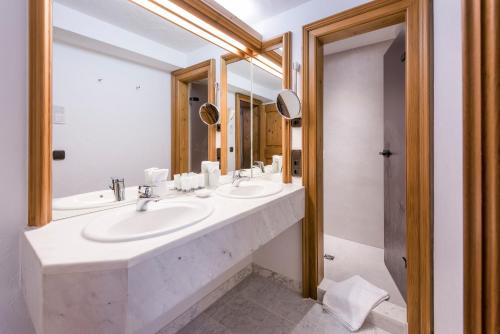 奥夫特尔施旺Sonnenalp Resort的浴室设有2个水槽和2面镜子