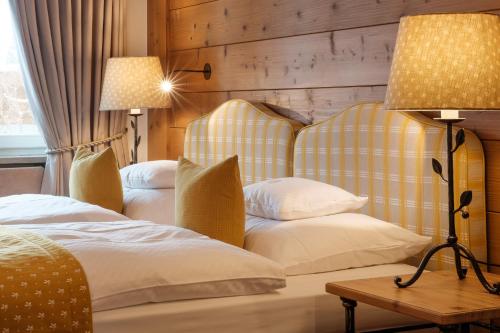 奥夫特尔施旺Sonnenalp Resort的酒店客房,设有两张床和一盏灯