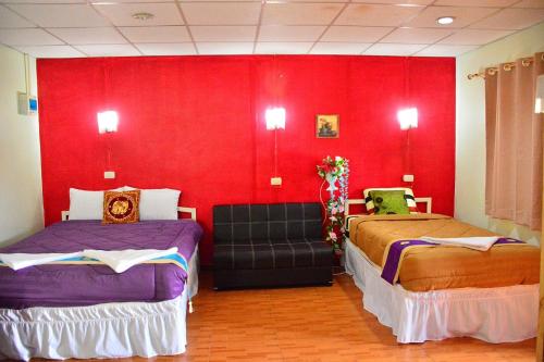 北碧Thai Garden​ Resort​ Kanchanaburi​的一间设有两张床和红色墙壁的客房