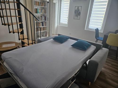 图卢兹Duplex - Palais de Justice的一张带蓝色枕头的病床