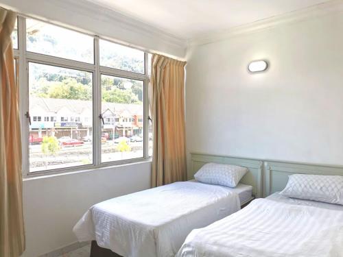 瓜埠Vive Inn的一间卧室设有两张床和窗户。