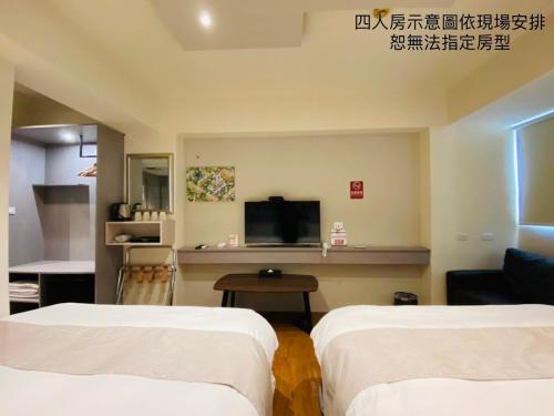 台中市达斯旅店的酒店客房设有两张床和一台平面电视。