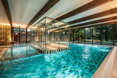派尔努Wasa Historical 1938 Boutique Hotel的一座带玻璃墙的室内游泳池