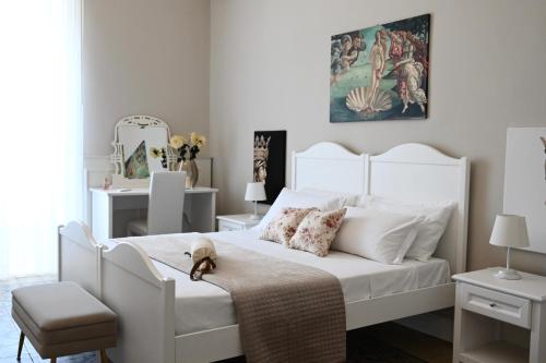 利卡塔Civico 10 Deluxe Room的卧室配有一张白色的床,里面放着一只动物