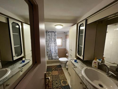 Bayt SāḩūrBeit Zaman hostel的浴室配有2个盥洗盆、卫生间和浴缸。