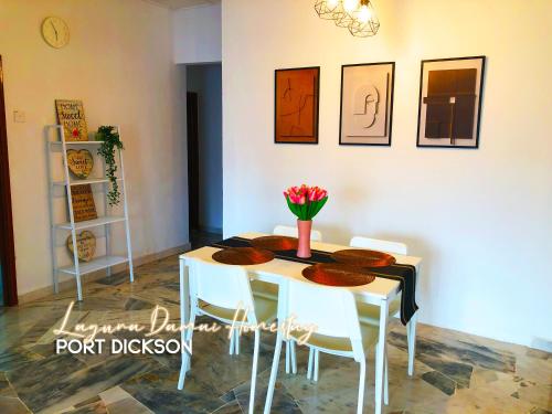 波德申Laguna Damai Homestay PortDickson - "PoolView & BeachNearby"的餐桌,配有白色椅子和鲜花