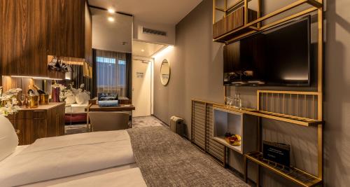 慕尼黑PLAZA Premium München的酒店客房配有一张床、一张书桌和一台电视。