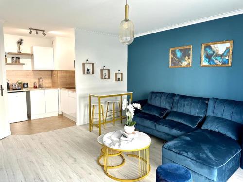 勒布朗-梅尼尔Perle rare « Le Cosy de CDG »的客厅配有蓝色的沙发和桌子