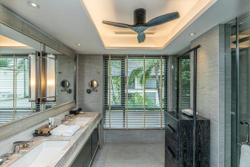 高兰Layana Resort & Spa - Adult Only - SHA Extra Plus的一间带两个盥洗盆和吊扇的浴室。