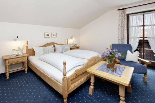 奥伯斯特多夫沃格勒豪斯公寓的卧室配有1张床、1张桌子和1把椅子