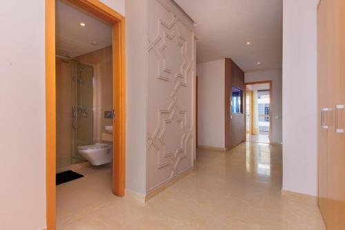 拉巴特Spacious Waterfront 3BR Flat in Marina Sale的走廊上设有带卫生间的浴室和门