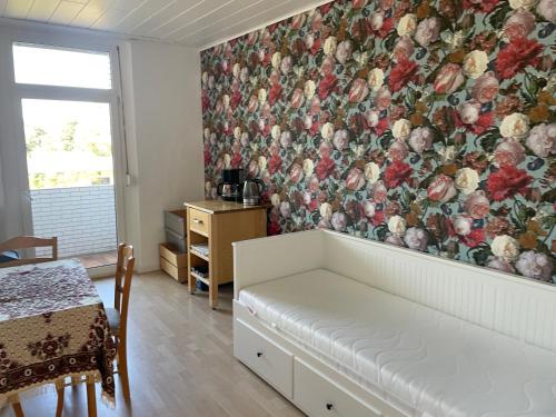 奥伯豪森2Schlafzimmer, Wohnküche&Balkon的客厅的墙上挂有花卉图案的壁纸