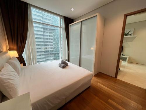 吉隆坡Soho Suites KLCC的卧室设有白色的床和大窗户