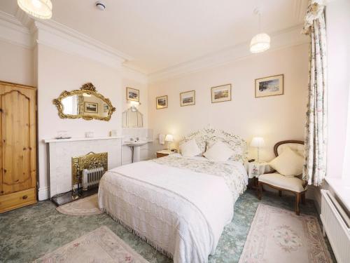 巴克斯顿Braemar Guest House的卧室配有白色的床和壁炉