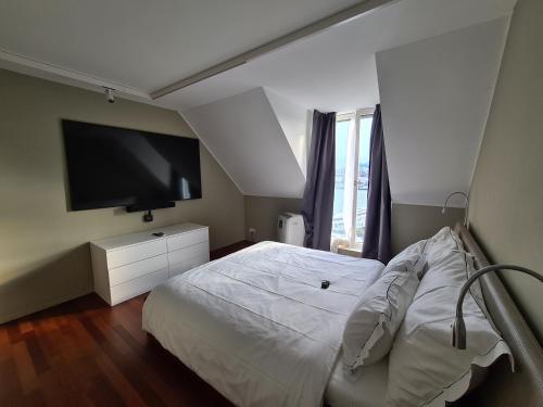 卢塞恩卢塞恩湖景公寓的卧室配有白色的床和平面电视。