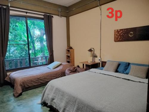 清迈奥尔迪花园公寓的一间卧室设有两张床和大窗户