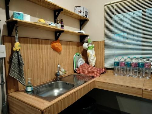 清迈奥尔迪花园公寓的厨房配有水槽和带水瓶的台面