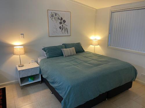 马奇Comfortable and well equipped Studio Apartment in Mudgee - Rest Easy Mudgee Studio的一间卧室配有一张大床和两盏灯