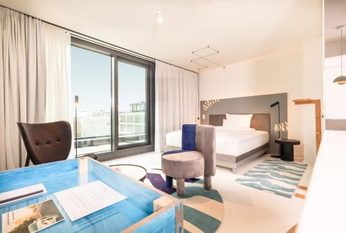 柏林KPM Hotel & Residences的配有一张床和一张书桌的酒店客房