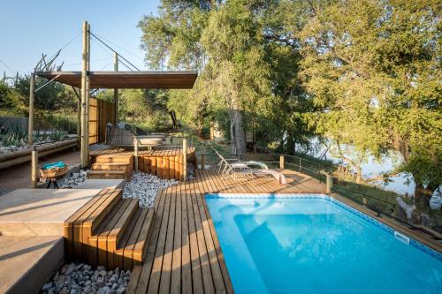 侯斯普瑞特Bundox River Lodge的一座带木甲板的游泳池,位于一座房子旁边