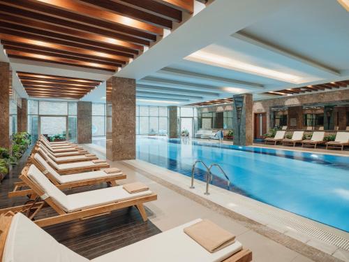 伊斯坦布尔Selectum City Ataşehir的酒店游泳池设有躺椅和游泳池
